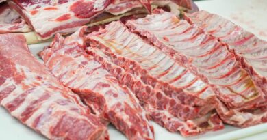 Close-up of fresh raw pork ribs neatly arranged on a cutting board, showcasing marbling.